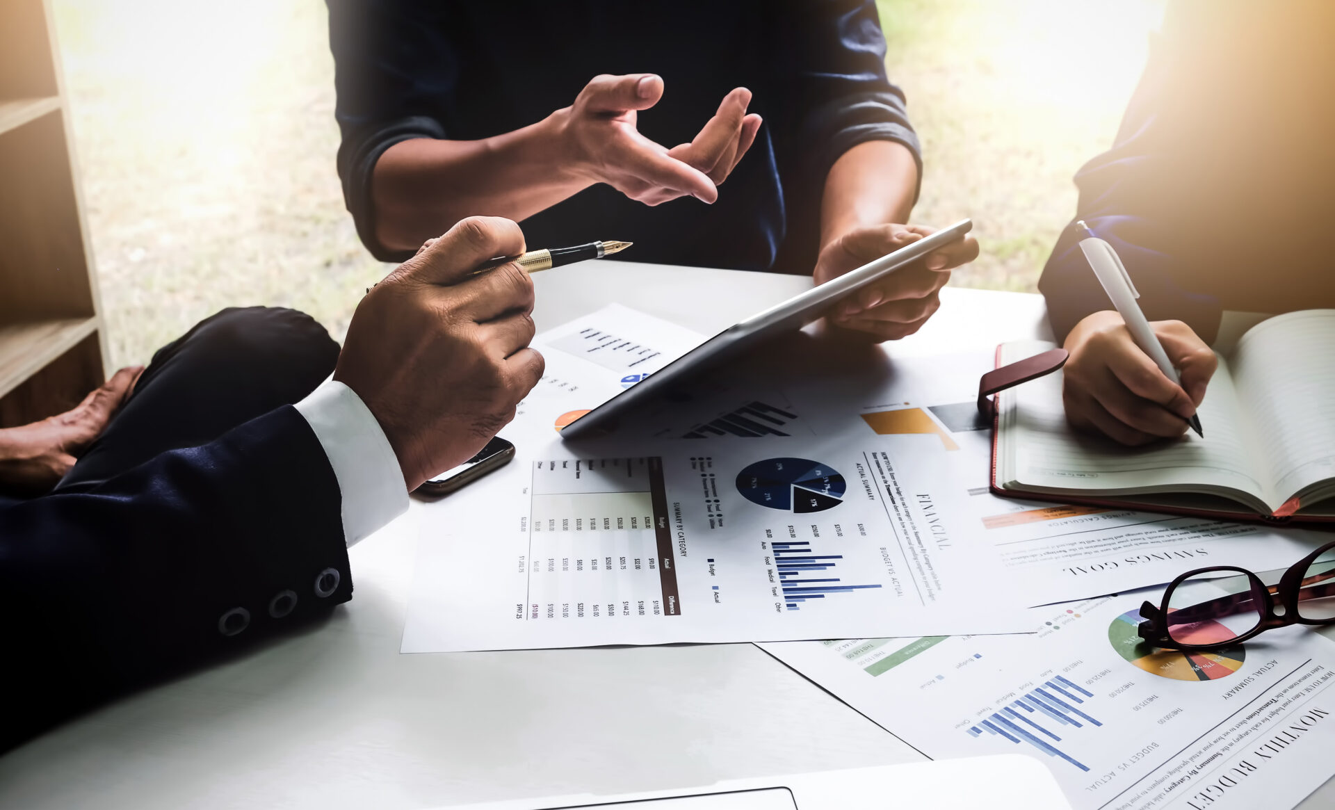 Business people using pen,tablet,notebook are planning a marketing plan to improve the quality of their sales in the future.